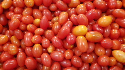 Lots of tomatoes on the shelves in the supermarket.