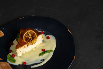 Classic cheesecake on a black background, dessert on a black background in a black plate