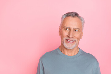 Photo of confident dreamy man pensioner dressed grey shirt looking empty space isolated pink color background