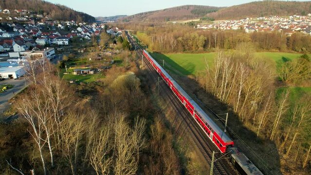 Aerial drone view of a train on the Deutsche bahn, spring, sunset in Hesse, Germany