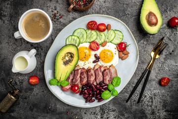 Healthy nutritious paleo keto breakfast diet lunch avocado, fried eggs, bacon, beans and coffee. Ketogenic diet concept. Restaurant menu, dieting, cookbook recipe top view