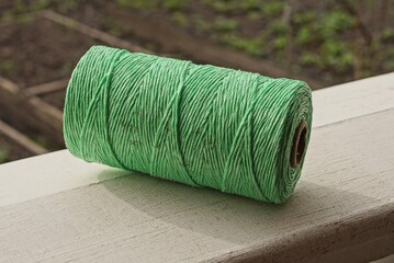 one large green coil of rope lies on a white table