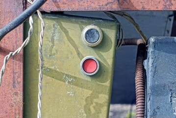 two old round buttons toggle switches on the green metal panel of an old electric machine