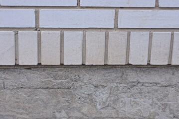 stone texture of gray concrete wall and white bricks on the street
