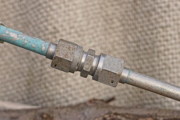 gray iron nuts screwed onto a old long metal pipe