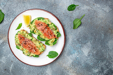 Two toasts whole grain bread with avocado paste and salmon. keto paleo diet. Delicious breakfast or snack. Restaurant menu, dieting, cookbook recipe top view
