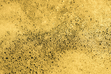 
background yellow foamy water close-up. abstract bubbles in white color
