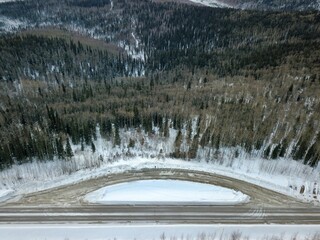 drone shot of a road and trees in Alaska