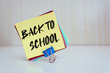 A white card with text of back to school and a fountain pen on a wooden desk, Back to School