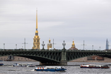 The Neva river in St. Petersburg with a floating pleasure boat overlooking the Trinity Bridge and the Peter and Paul Fortress