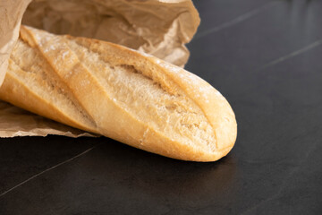 White loaf in paper, on a black background