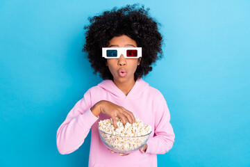 Photo of young impressed girl omg eat pop corn watch movie weekend isolated over blue color...