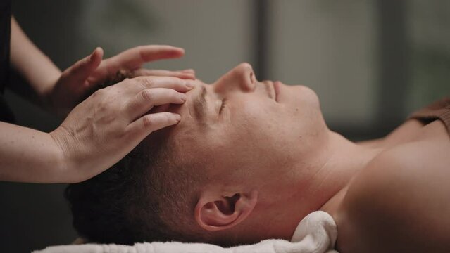 manipulative therapy for healing headache, man is relaxing in massage parlor of osteopathy clinic