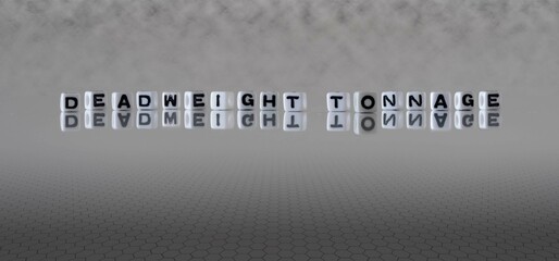 deadweight tonnage word or concept represented by black and white letter cubes on a grey horizon...