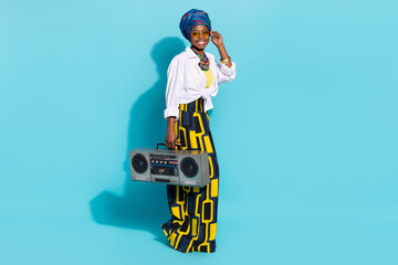 Photo of cute lady from masai tribe hold cassette boom box wear native clothes isolated blue pastel...