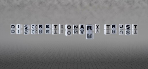 discretionary trust word or concept represented by black and white letter cubes on a grey horizon background stretching to infinity - obrazy, fototapety, plakaty