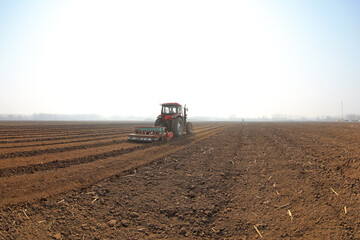 Fototapeta premium Farmers drive planters to plant peas in the fields, North China