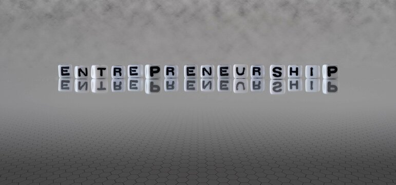 entrepreneurship word or concept represented by black and white letter cubes on a grey horizon background stretching to infinity