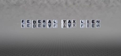 federal tax lien word or concept represented by black and white letter cubes on a grey horizon background stretching to infinity - obrazy, fototapety, plakaty