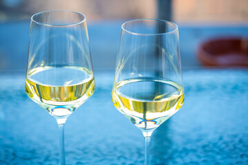 2 wine glasses on glass table, balcony