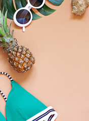 Summer tropical vacation concept frame with sunglasses and beach wear on the beige background . Top...