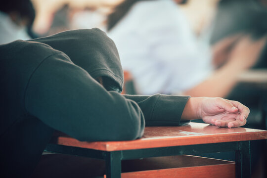 Tired students sleeping during exam test in classroom