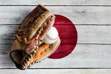 Leather Baseball Glove With Ball on Painted Japanese Flag. Japan is a major baseball nation in the world.  - 502958944