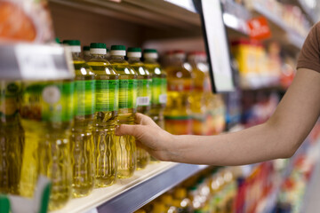 Fototapeta na wymiar Woman buying cooking oil in supermarket, close-up