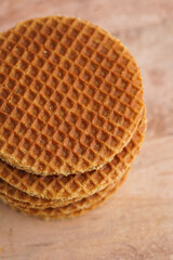 Stroopwafel - traditional dutch sirup waffles with caramel filling - stacked on top of each other on a wooden board, white kitchen