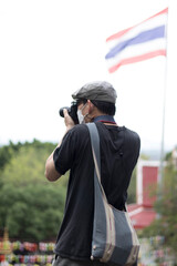 An adult is taking pictures with a camera in a tourist attraction with a stern expression.