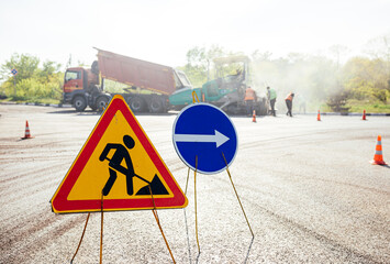 Road works sign on the road. Repair work of road signs and a bypass arrow
