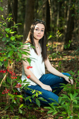 A beautiful serious teen brunette girl looking away from the camera towards the future in a wooded area in the spring