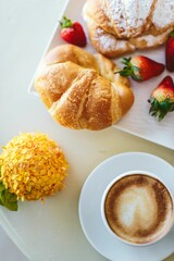 Fresh croissant with coffee and flowers. Flatlay breakfast 