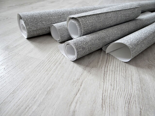 Wallpapering.Rolls of grey wallpaper