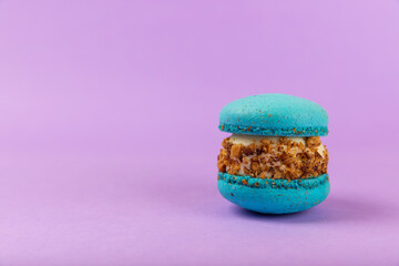 French macaroons on a lilac background. Macarons with dor blue and pear. French dessert. Sweet table.Copy space.Place for text.