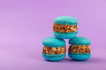 French macaroons on a lilac background. Macarons with dor blue and pear. French dessert. Sweet table.Copy space.Place for text.