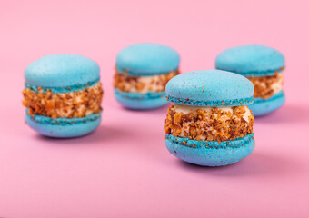 French macaroons on a pink background. Macarons with dor blue and pear. French dessert. Sweet table.Copy space.Place for text.