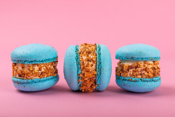 French macaroons on a pink background. Macarons with dor blue and pear. French dessert. Sweet table.Copy space.Place for text.