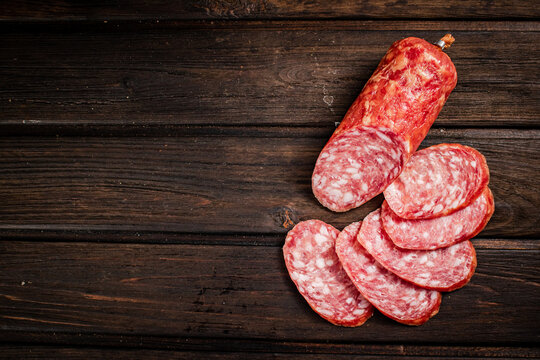 Sliced delicious salami sausage on the table. On a wooden background. High quality photo