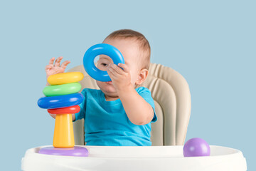 toddler 12-17 months learning to assemble a pyramid of colored rings in the correct order,...