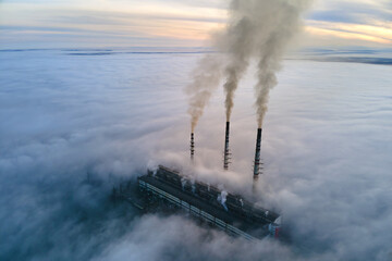 Aerial view of coal power plant high pipes with black smoke moving up polluting atmosphere at sunset - obrazy, fototapety, plakaty