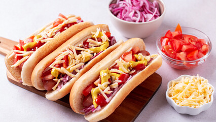 Homemade hotdogs with sausage. onion, tomato and cheese on light gray background