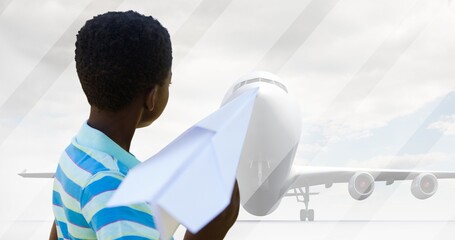 Multiple image of african american boy flying paper plane and airplane on runway against sky