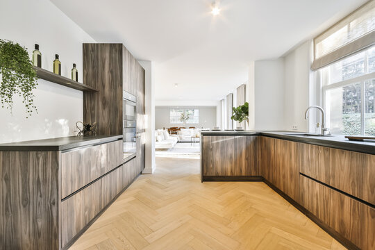 Contemporary kitchen with wooden furniture separated from living room with counter