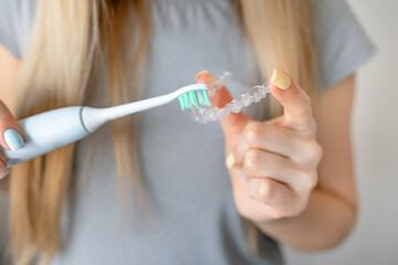 Cleaning tooth aligners. Washing and removing organic residues with using toothbrush from...