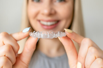 Close up of woman hold transparent aligners. Taking care of teeth. Orthodontic treatment for...