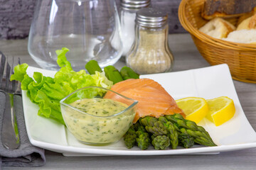 delicious salmon with asparagus and sauce on white plate