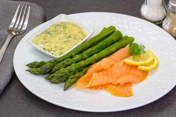 delicious salmon with asparagus and sauce on white plate
