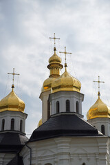 Fototapeta na wymiar Gilded domes of an ancient Orthodox church against the sky. Catherine's Church is a functioning church in Chernihiv, Ukraine. St. Catherine's Church was built in the Baroque style.