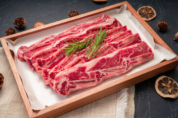 Raw Cross Cut Short Ribs beef on wooden plate, Beef Short Ribs (Sliced) on wooden background.